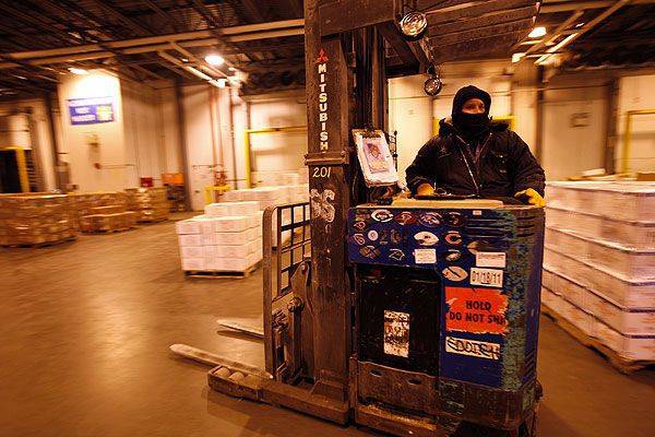 man on forklift wearing a cold suit loading a refrigerated truck trailer