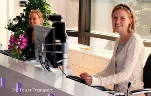 An image of our 2 receptionists at tritown transport, they are both blonde and very attractive, they are smiling and looking at the camera 
