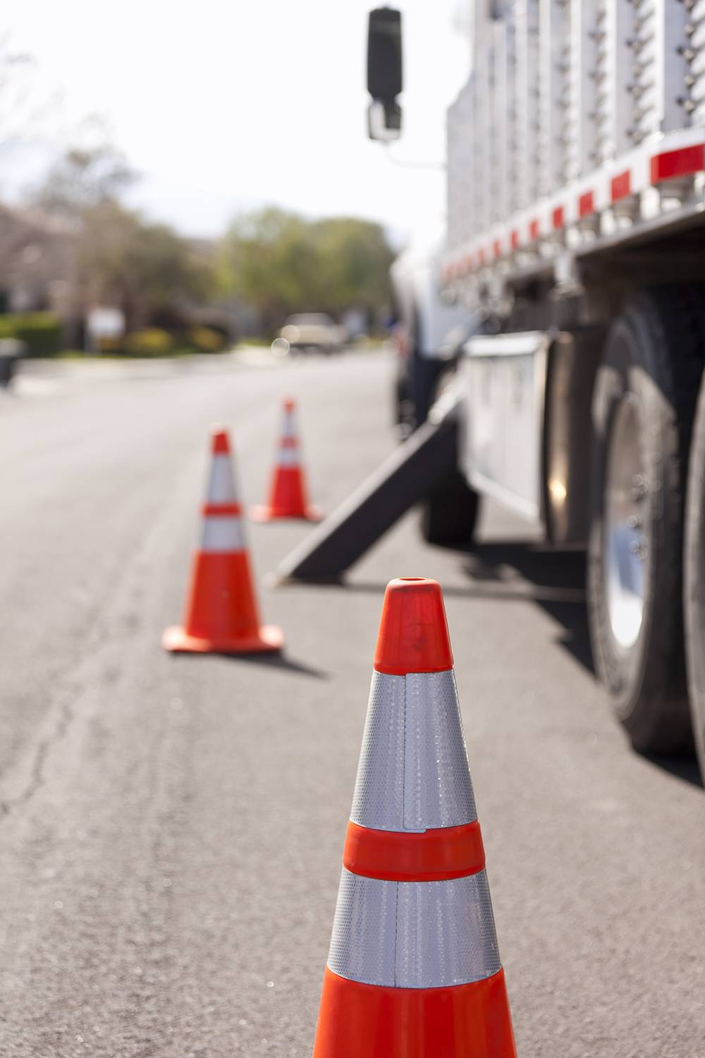 Orange hazard safety cones and work truck on the road